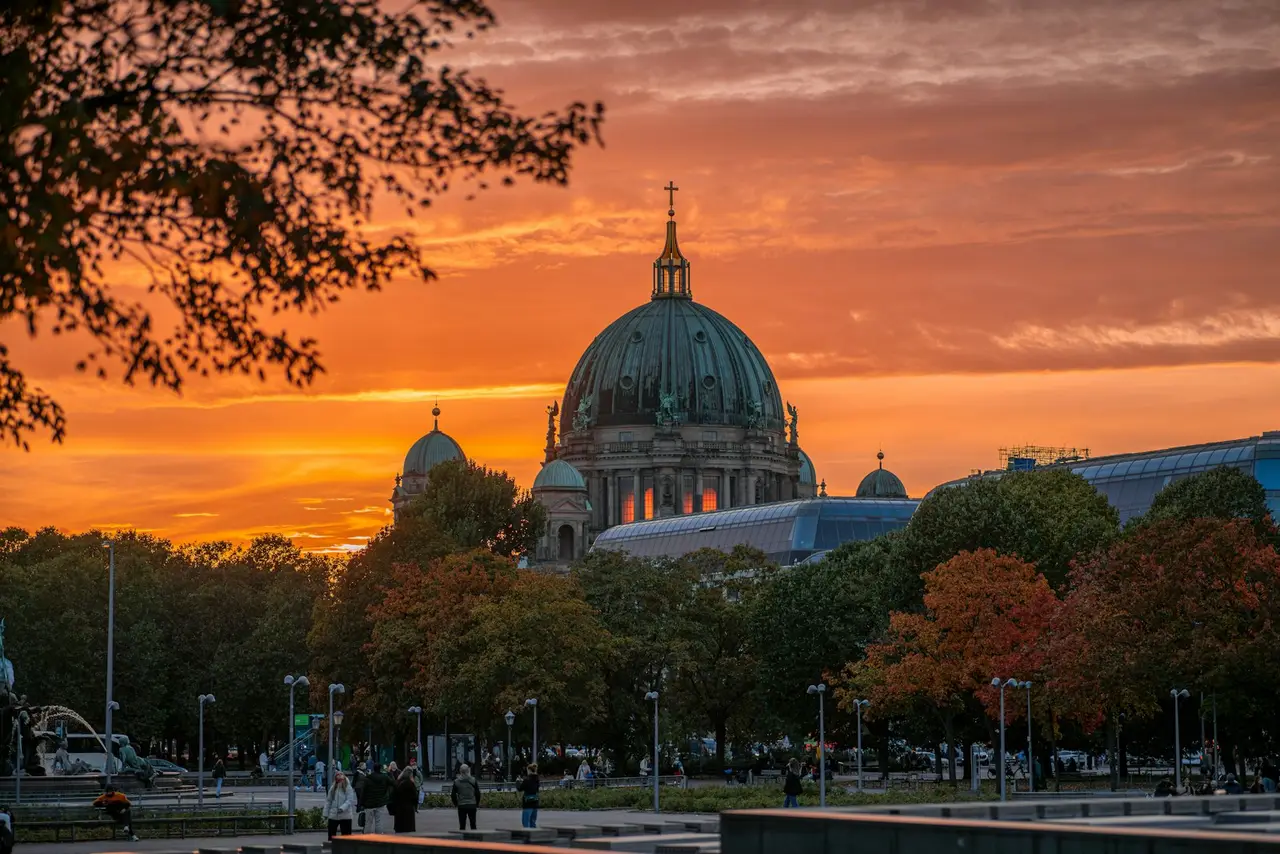 A sunset view of a large building with a dome